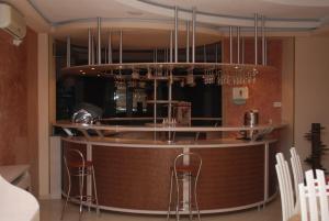 un bar avec des chaises et un comptoir avec des lustres dans l'établissement Hotel Migador, à Eforie Sud