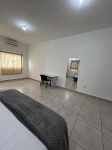 a bedroom with a bed and a desk in it at Flat Monte Mor Jardim Monte Verde in Monte Mor