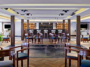 ein Restaurant mit einer Bar mit Holztischen und -stühlen in der Unterkunft Mövenpick Royal Lily Nile Cruise, Every Monday Four Nights From Luxor, Every Friday Three Nights From Aswan - Including Excursions & Sightseeing in Luxor