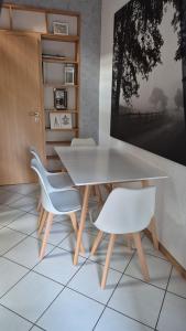 une salle à manger avec une table blanche et deux chaises dans l'établissement Gemütliches Ferienhaus im Herzen von Cuxhaven, à Cuxhaven