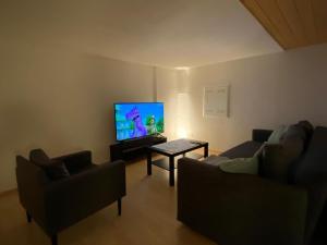 a living room with two couches and a flat screen tv at Bauernhof Sal in Bütschwil +23 photos