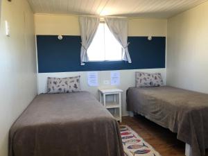 ein Schlafzimmer mit zwei Betten und einem Fenster in der Unterkunft VIssershuisies at Grootvlei Guest Farm 