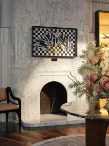 a living room with a fireplace and a table at Mandarin Oriental, Vienna in Vienna