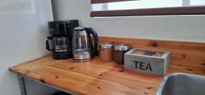 una encimera de madera con una cafetera y una caja de té encima en Deluxe Studio, en Oranjestad