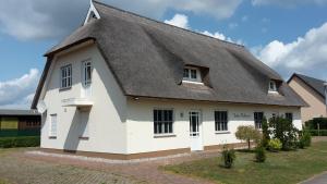 ein großes weißes Haus mit einem Strohdach in der Unterkunft Ferienhaus für 4 Personen ca 85 qm in Garz auf Usedom, Ostseeküste Deutschland Usedom in Garz