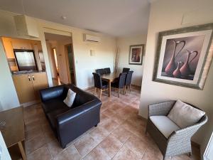 Una sala de estar con un sofá y sillas y una mesa. en Jacaranda A, en Pedreguer