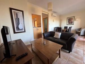 una sala de estar con un sofá y una mesa en Jacaranda A, en Pedreguer