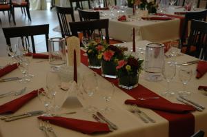 einen Tisch mit Weingläsern und roten Servietten in der Unterkunft Landhotel Sendes in Senden