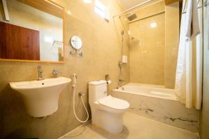 ein Badezimmer mit Waschbecken und Toilette und Waschbecken in der Unterkunft Koramangala SeasonsSuites in Bangalore + 10 Fotos