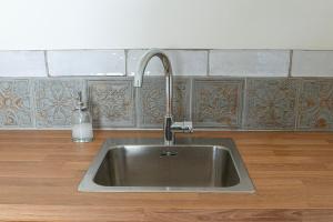 Un fregadero de cocina con un grifo sobre una encimera en Hohenberg Häuschen, en Hellenthal