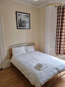 une chambre avec un lit avec une serviette dessus dans l'établissement Private Room, Tyne Wear, à Sunderland