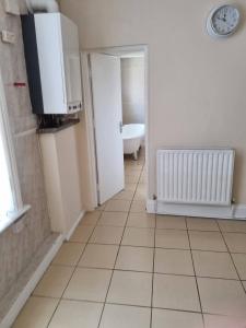 La salle de bains est pourvue de carrelage blanc et de toilettes. dans l'établissement Private Room, Tyne Wear, à Sunderland