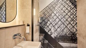 ein Badezimmer mit Waschbecken und Glasfenster in der Unterkunft Campanile Paris Ouest - Pont de Suresnes in Suresnes + 80 Fotos