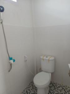 ein Badezimmer mit einer weißen Toilette in einem Zimmer in der Unterkunft Pandava House Lombok in Lombok International Airport