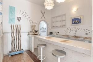 eine weiße Küche mit zwei Spülbecken und zwei Hockern in der Unterkunft Ventanas De Lanzarote in Playa Quemada + 59 Fotos