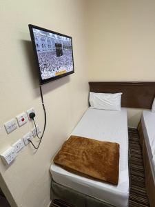 Ένα ή περισσότερα κρεβάτια σε δωμάτιο στο فندق ضيوف المقام الذهبي توصيل مجاني للحرم - Diouf Al Maqam Al Dahabi Hotel Free Shuttle Service to Haram