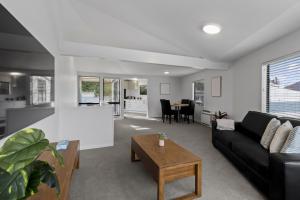 ein Wohnzimmer mit einer schwarzen Couch und einem Tisch in der Unterkunft Central 2 bed Apt - views pool walk to town in Queenstown