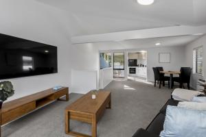 ein Wohnzimmer mit Sofa und Tisch in der Unterkunft Central 2 bed Apt - views pool walk to town in Queenstown