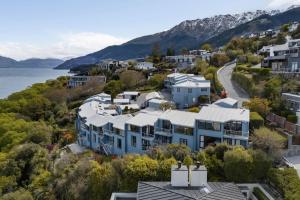 eine Luftansicht eines Hauses auf einem Hügel neben dem Wasser in der Unterkunft Central 2 bed Apt - views pool walk to town in Queenstown