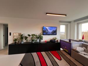 Una sala de estar con un sofá y un televisor en la pared. en Cliff City Home, en Gdynia