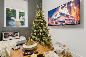 a living room with a christmas tree and a tv at The Gate House-Wyndale Living- West Malvern in Great Malvern