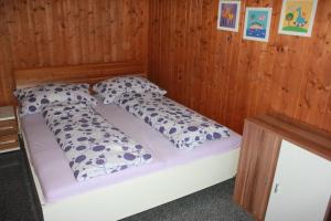 a bed in a wooden room with two pillows at Fäsch in Flumserberg