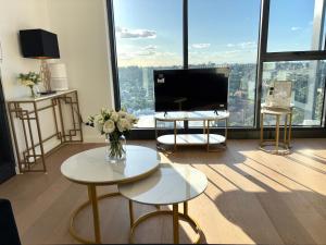 a living room with a television and a vase of flowers at The Luxury Penthouse at Spring Square in Bankstown