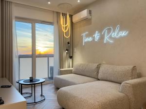 un salon avec un canapé et un panneau indiquant qu'il est temps de se détendre dans l'établissement URBAN APARTMENTS GLOBAL, Jacuzzi, 8th floor No 03, Free Garage, Self Check-in, No deposit, à Katowice