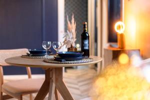 a table with a bottle of wine and glasses on it at L'Appart Cosy- Hyper centre- Vue sur la collégiale in Brive-la-Gaillarde +10 photos