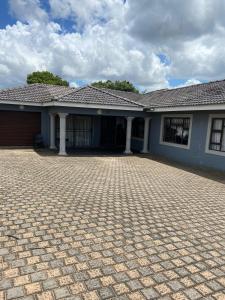 une maison avec une allée en briques devant elle dans l'établissement JayBee Guest House, à Richards Bay