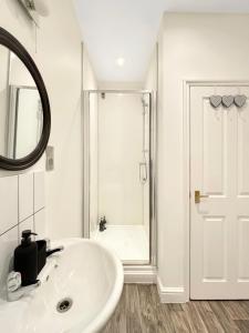 a white bathroom with a sink and a mirror at Free Parking, Central, Spacious, 2 bed Apartment sleeps 8 Newark Town Centre - Amaya Fourteen in Newark upon Trent +4 photos