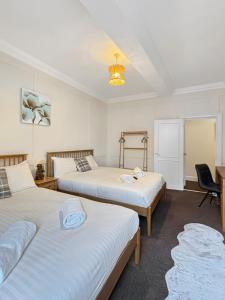 a bedroom with two beds and a desk at Free Parking, Central, Spacious, 2 bed Apartment sleeps 8 Newark Town Centre - Amaya Fourteen in Newark upon Trent