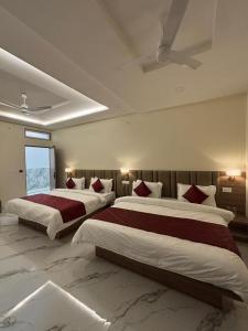 two beds in a large bedroom with a ceiling at The Silk Route Resort in Chanderi