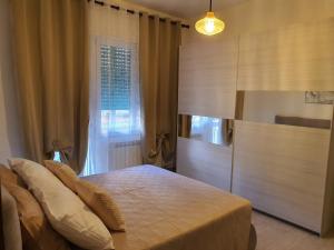 a bedroom with a bed and a large window at Infinity Karla House 2 in Chioggia