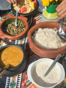 a table topped with bowls of food and bowls of rice at Mango Trails - Farm Stay, Camping & Day Outing near Bangalore in Talai +26 photos