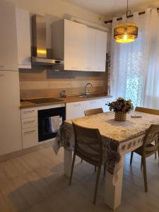 een keuken met een tafel met stoelen en een wastafel bij Infinity Karla House 2 in Chioggia