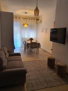 een woonkamer met een bank en een tafel met stoelen bij Infinity Karla House 2 in Chioggia