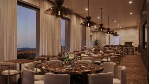 a restaurant with tables and chairs and large windows at 360 Hotel Boutique and Spa in Selfoss
