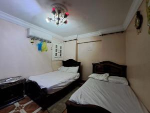 a room with two beds and a chandelier at BLUE Sky in Alexandria