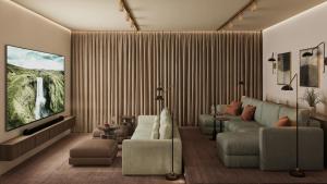 a living room with a couch and a flat screen tv at 360 Hotel Boutique and Spa in Selfoss