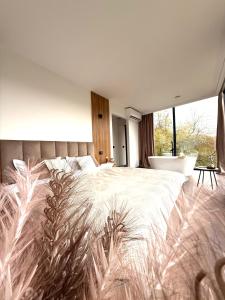 a bedroom with a large bed and a bath tub at Nest House in Dubova