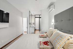 une chambre avec un grand lit blanc et un canapé dans l'établissement Beachfront Le Cerisier Trou Aux Biches, Mon Choisy, à Mont Choisy