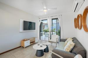 un salon avec un canapé et une table dans l'établissement Beachfront Le Cerisier Trou Aux Biches, Mon Choisy, à Mont Choisy