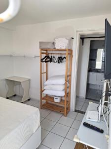 a room with a bed and a shelf with towels at Polyglot Family in Natal +13 photos