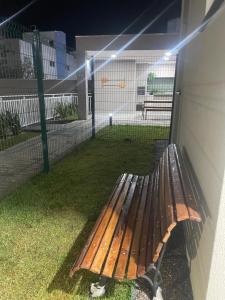 a wooden bench sitting on the side of a building at Apartamento Itapoá in Itapoa