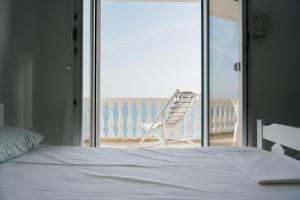 a bedroom with a bed and a chair on the beach at Irini in Mesochórion
