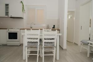 a white kitchen with a table and chairs in it at Irini in Mesochórion