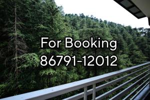 a sign that reads for booking in front of a forest at Staynest BNB - Balcony Rooms - 3BHK Apartments in Shimla +17 photos