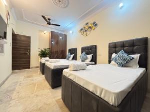 a bedroom with two beds and a ceiling fan at Homestay Fortune Home Ansal Golf Link 1 in Greater Noida