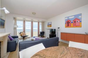 Una sala de estar con un sofá azul y una mesa. en Sea view 02-04, en Mellet